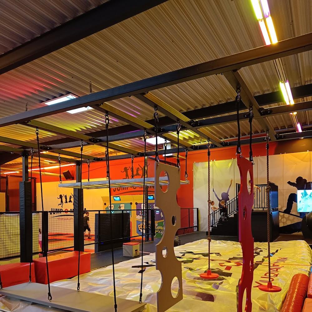 Indoor obstacle course with hanging ropes and platforms.